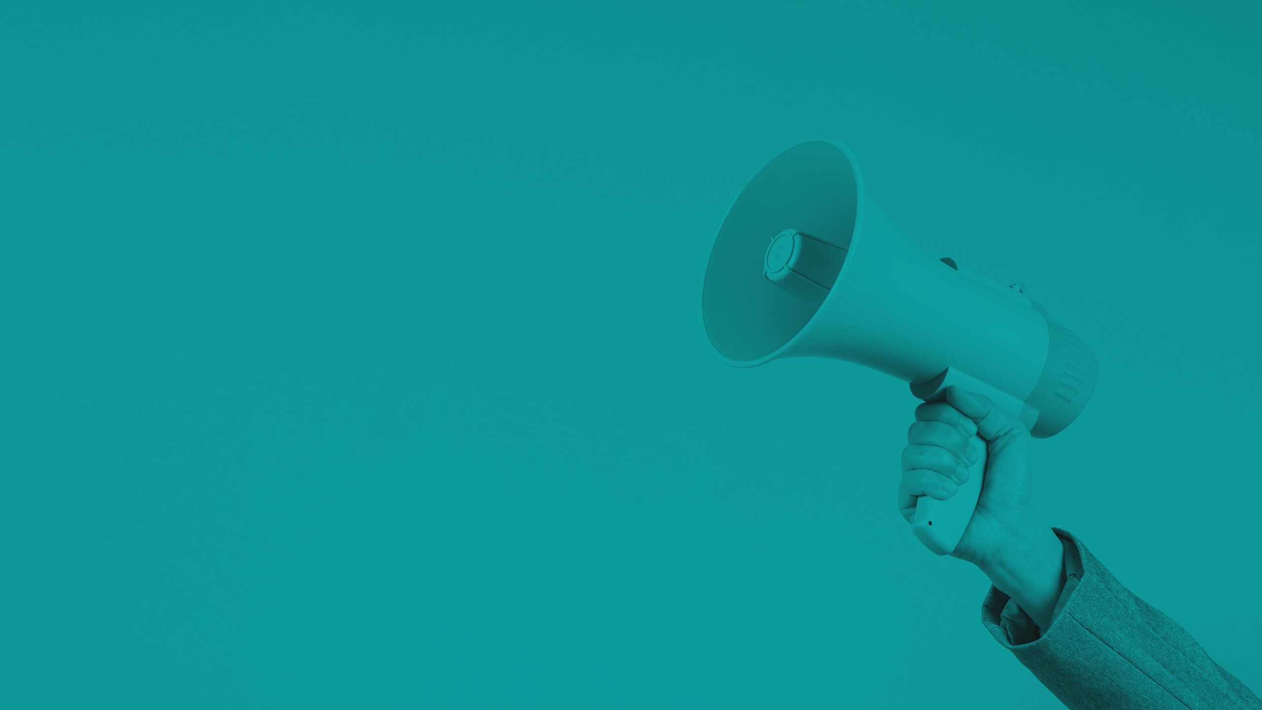 Hand holding a megaphone against a solid teal background, symbolizing communication or announcement.
