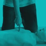 Person demonstrating chest compressions on an adult CPR training manikin.