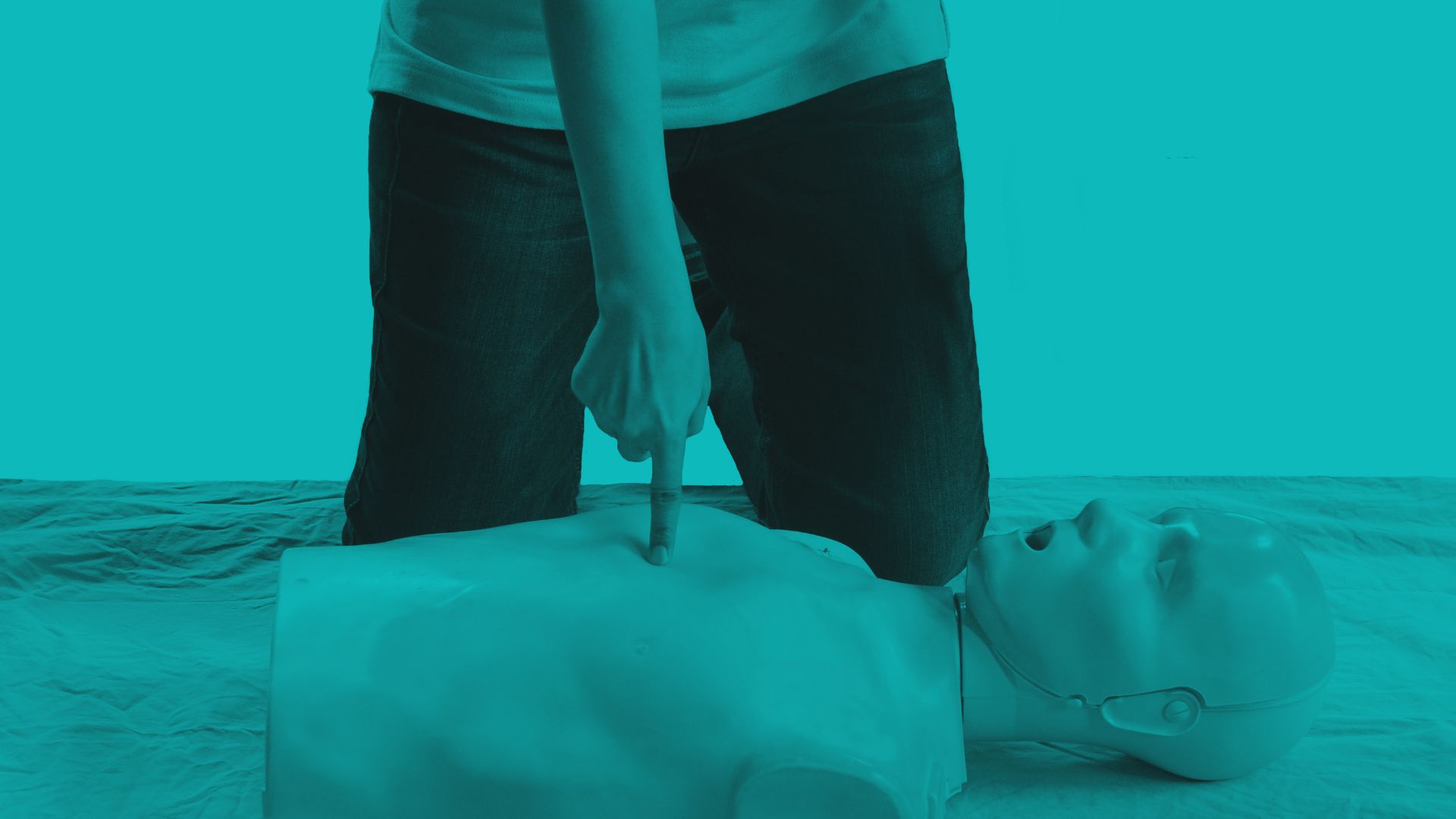 Person demonstrating chest compressions on an adult CPR training manikin.
