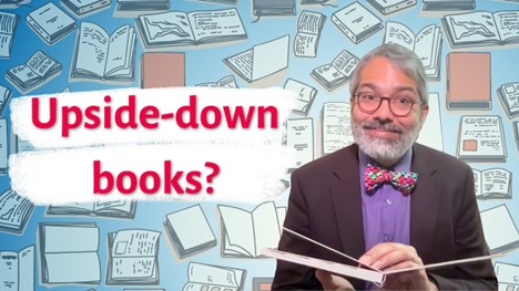 A person in a suit holding an upside-down book, with illustrated books in the background and text reading ‘Upside-down books?’