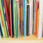 Close-up of colorful children's books lined up on a library or classroom bookshelf.