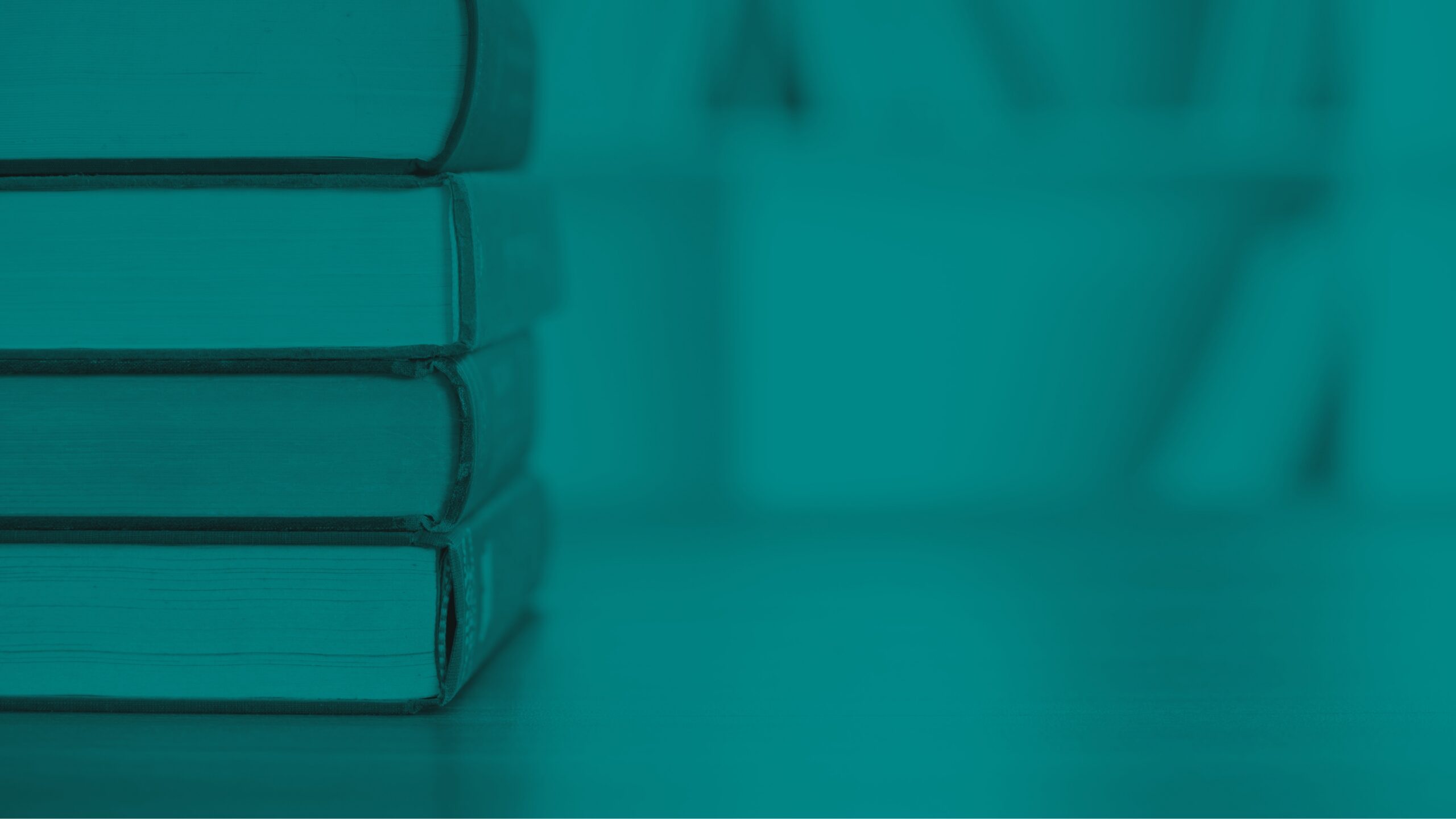 Stack of hardcover books on a table with a blurred bookshelf background.